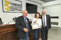 Il presidente Araer Maurizio Garlappi (a sinistra) consegna l'Attestato di Solidarietà a Eleonora Bortolani. Al suo fianco Claudio Bovo, direttore Araer