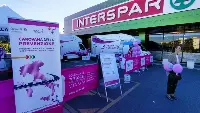 Uno stand della "Carovana della Prevenzione" Komen davanti a un supermercato Despar