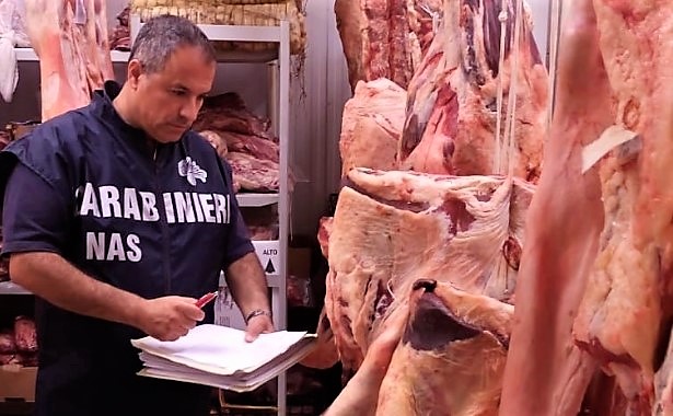 Carabiniere del Nas controlla carne fresca in uno stabilimento di macellazione
