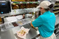 Preparazione pollo fritto a ristorante Popeyes a Roma